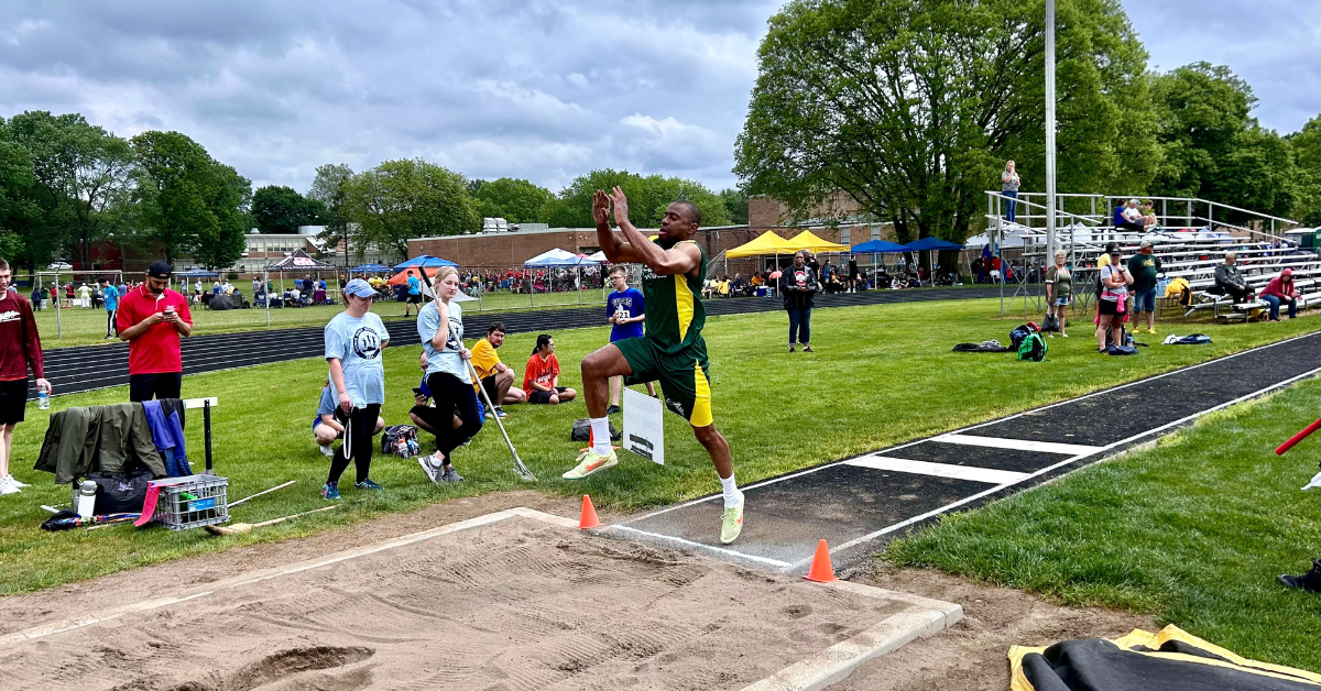 athlete in mid jump into sand pit